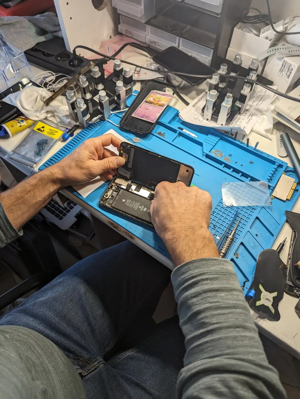 Réparation d'un smartphone sur le plan de travail de l'atelier